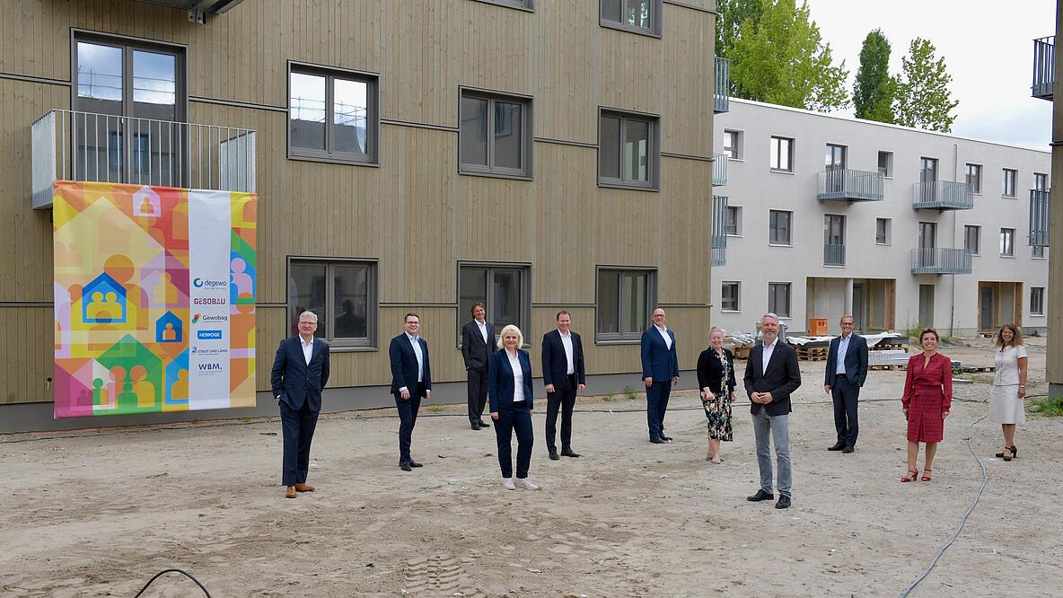 Außenaufnahme zeigt die Gäste der Neubautour vor einem Neubau.