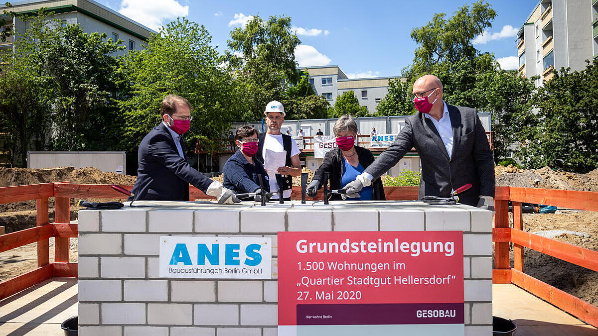 Die vier Redner legen den Grundstein auf der Baustelle im Quartier Stadtgut Hellersdorf.