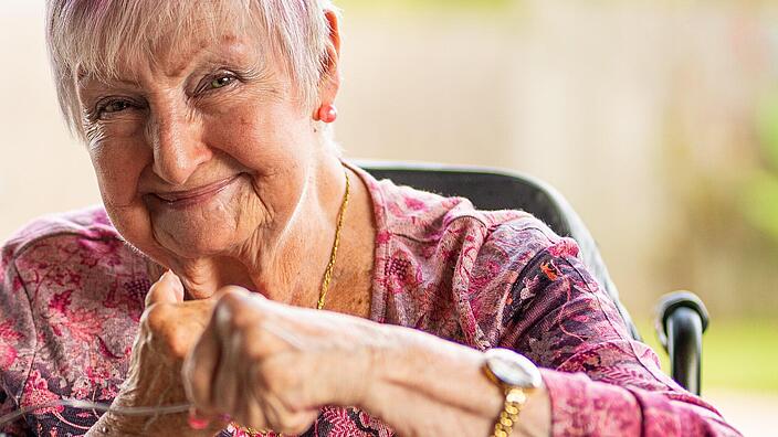 Aufnahme zeigt eine lächelnde Seniorin. 
