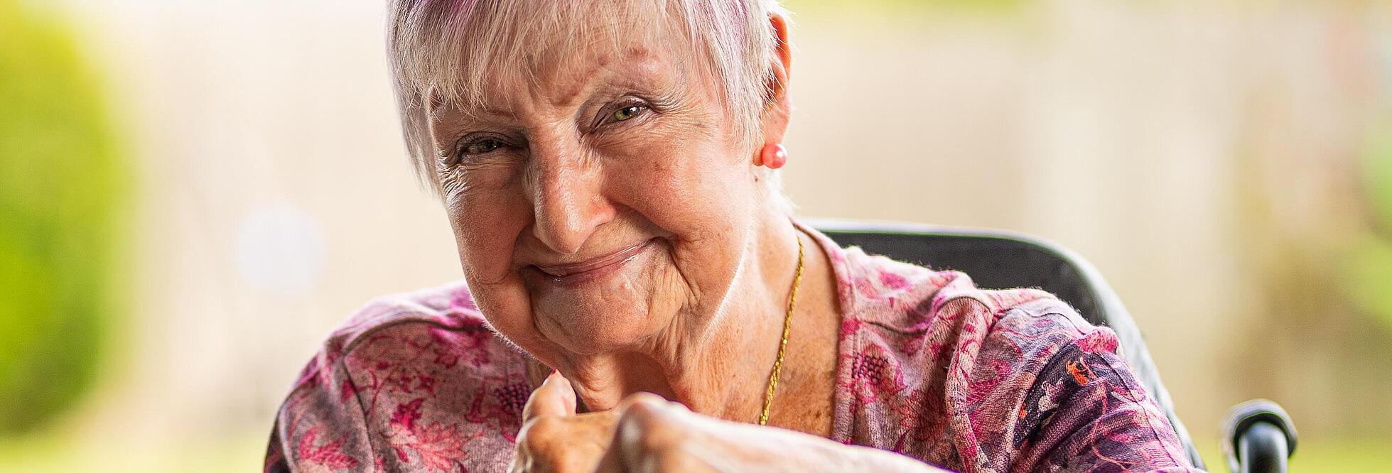 Aufnahme zeigt eine lächelnde Seniorin. 