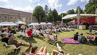 Kunstfest-Besucher auf einer Wiese vor der Bühne