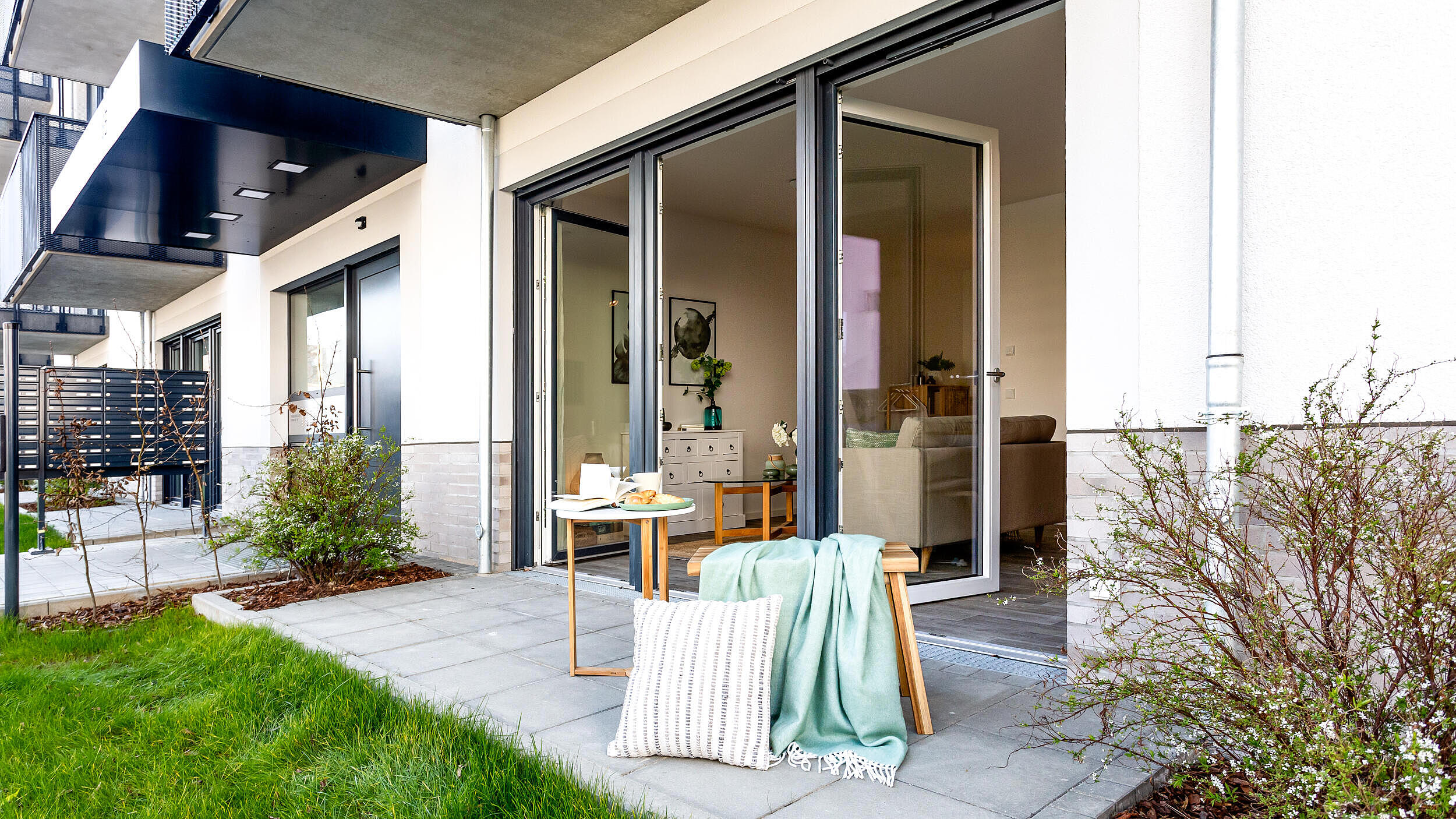 Außenaufnahme zeigt eine Terrasse mit Sitzmöbeln im Neubau in der Tangermünder Straße