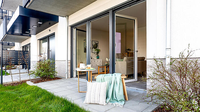 Außenaufnahme zeigt eine Terrasse mit Sitzmöbeln im Neubau in der Tangermünder Straße