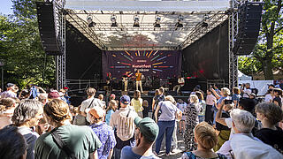 Kunstfest-Publikum steht vor der Bühne.