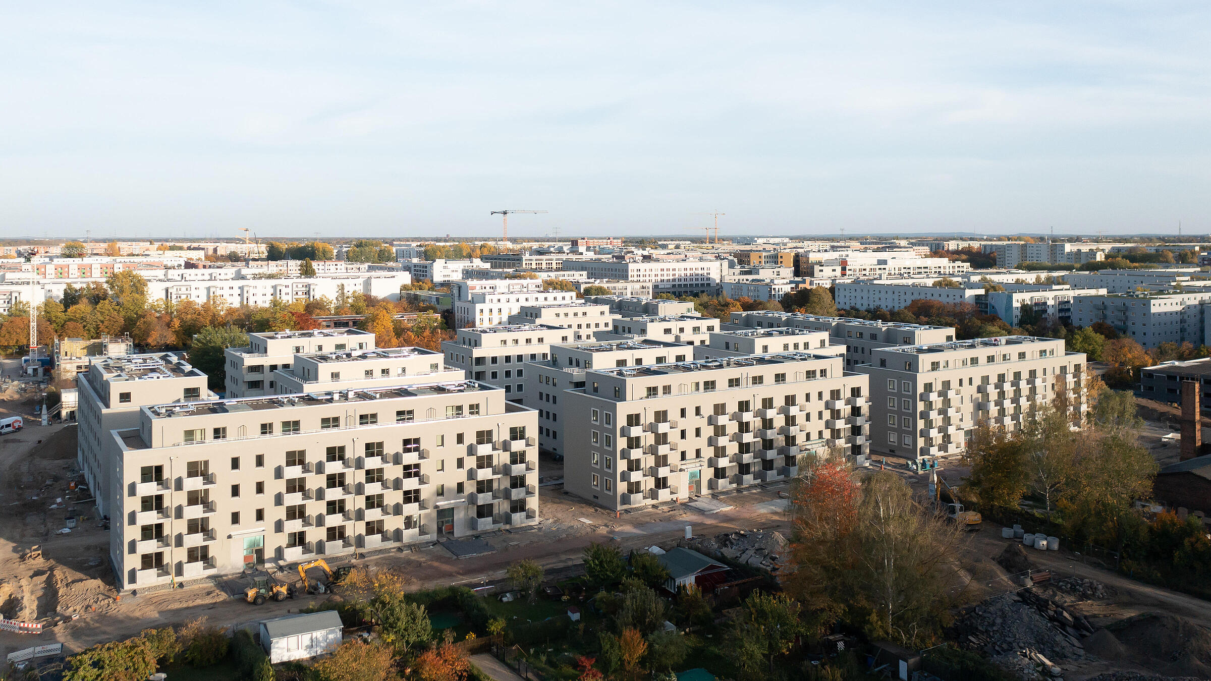 Luftaufnahme einer modernen Wohnanlage mit mehreren Wohnhäusern, die sich gerade im Bau befinden