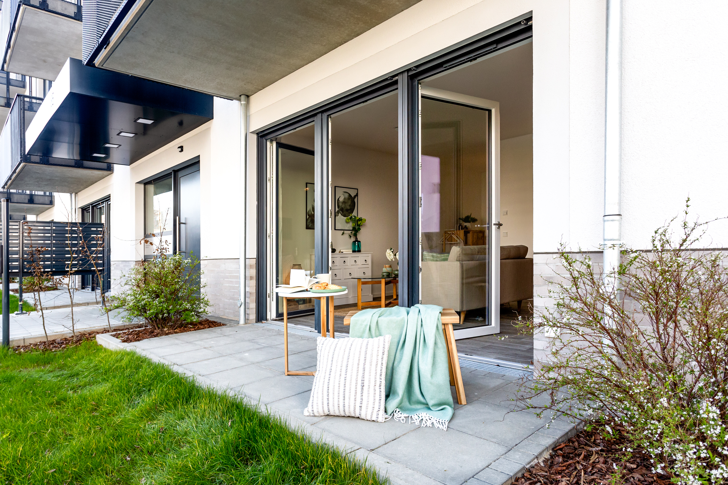 Außenaufnahme zeigt eine Terrasse mit Sitzmöbeln im Neubau in der Tangermünder Straße