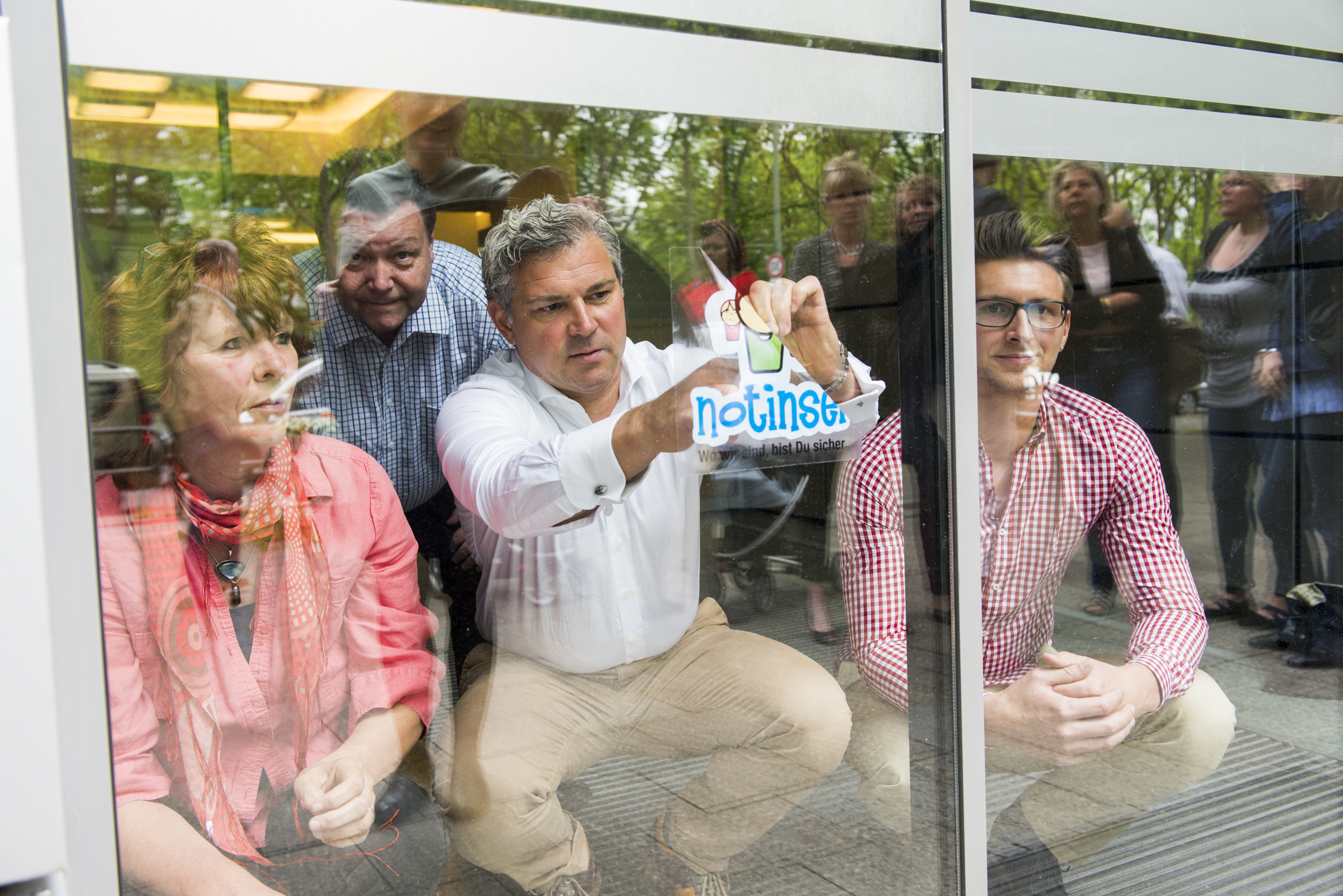 Menschen vor einer Glasscheibe