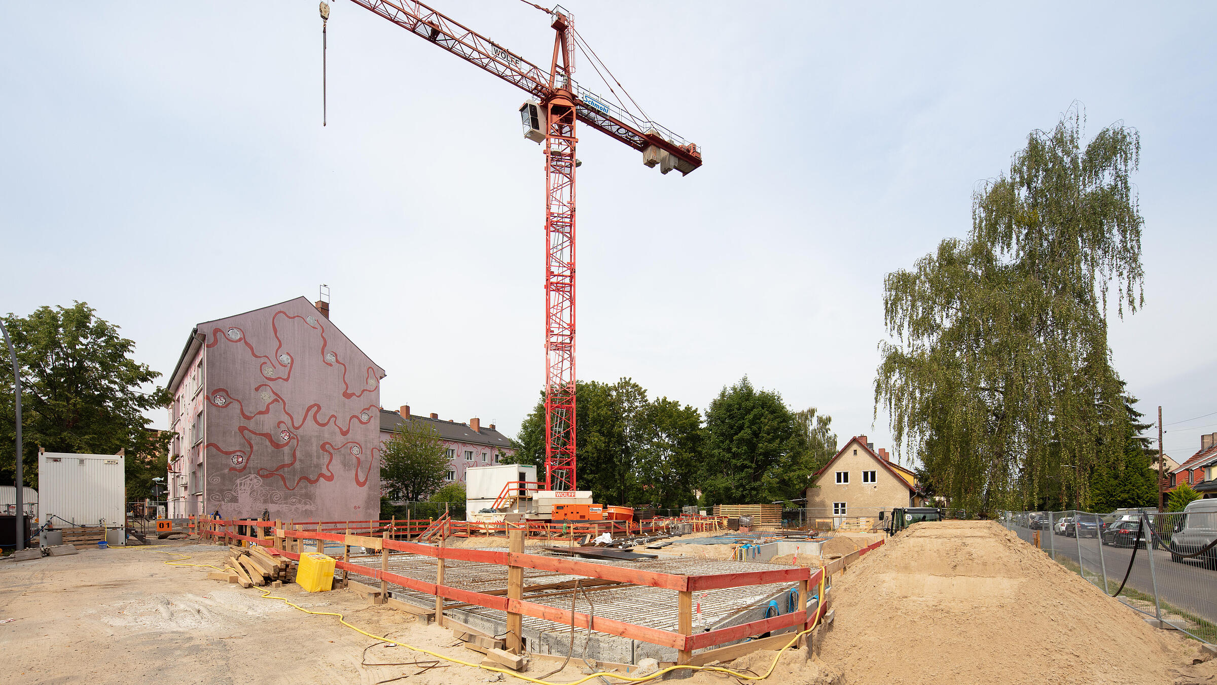 Außenaufnahme aus dem Juni 2019 zeigt die Baustelle der Gustav-Adolf-Str. mit einem Erdaushub und einem Kran.